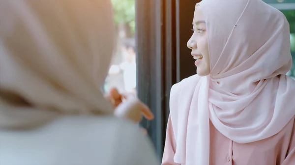 若い美しいアジアのムスリム女性は 明るい晴れた日にコーヒーショップで携帯電話で働いて遊ぶリラックスした瞬間を楽しんでいます — ストック写真