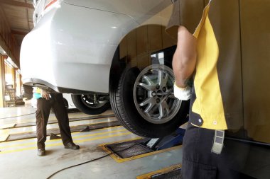 Tamirat yapan, fren diskini öğüten ve bir oto tamirhanesinde eskimiş fren pedlerini değiştiren bir tamirci. Araç güvenliği kavramı.