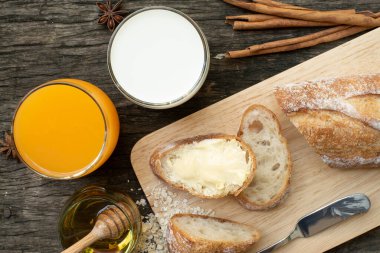 Yeni pişirilmiş geleneksel İtalyan Ciabatta ekmeklerinin ahşap bir masada servis edilmek üzere dilimlenip dilimlendiği yakın plan bir üst görüntüsü.