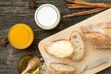 Yeni pişirilmiş geleneksel İtalyan Ciabatta ekmeklerinin ahşap bir masada servis edilmek üzere dilimlenip dilimlendiği yakın plan bir üst görüntüsü.