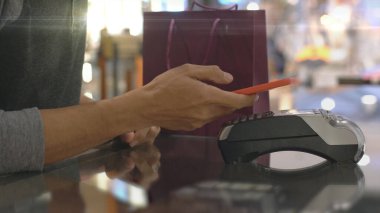 Cep telefonu kullanan üst düzey bir Asyalı Müslüman adam. NFC kimlik doğrulama ve kimlik doğrulama ödemesi ile birlikte bir satış terminalinde ürün almak için çok akıllıca bir hareket.