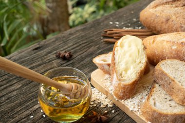 Yeni pişirilmiş geleneksel İtalyan Ciabatta ekmeklerinin ahşap bir masada servis edilmek üzere dilimlenip dilimlendiği yakın plan bir üst görüntüsü.