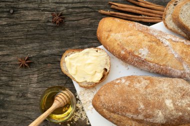 Yeni pişirilmiş geleneksel İtalyan Ciabatta ekmeklerinin ahşap bir masada servis edilmek üzere dilimlenip dilimlendiği yakın plan bir üst görüntüsü.