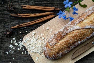 Yeni pişirilmiş geleneksel İtalyan Ciabatta ekmeklerinin ahşap bir masada servis edilmek üzere dilimlenip dilimlendiği yakın plan bir üst görüntüsü.