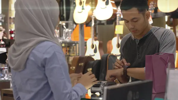 Upwardly Mobile Asian Muslim Man Using Mobile Phone Smartwatch Pay — Stock Photo, Image