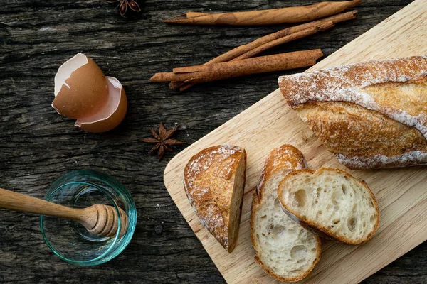 Yeni pişirilmiş geleneksel İtalyan Ciabatta ekmeklerinin ahşap bir masada servis edilmek üzere dilimlenip dilimlendiği yakın plan bir üst görüntüsü.