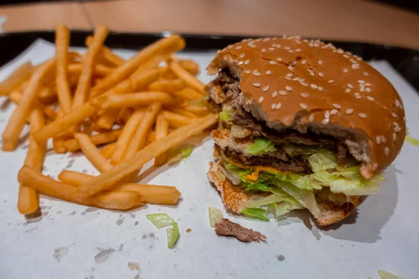 Κοντινό Πλάνο Του Ένα Δάγκωμα Διπλό Cheeseburger Ένα Δίσκο Φρεσκομαγειρεμένα — Φωτογραφία Αρχείου