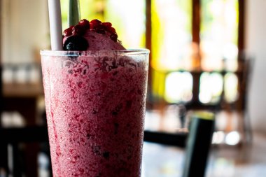 Penceresinden sabah ışığı süzülen rahat bir restoran pencerenin yanında iki kişilik küçük bir masada sıcak bir ortam yaratıyor.