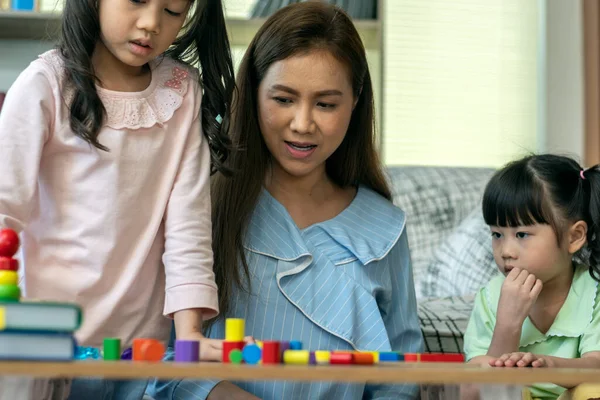 Beautiful Asian Mother Busy Working While Looking Teaching Her Children — Stock Photo, Image