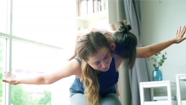 一位亚洲母亲和她的女儿一起 在明亮明亮 阳光灿烂的早晨客厅里教和练习瑜伽 重点是伸展身体和精确的身体运动 — 图库视频影像