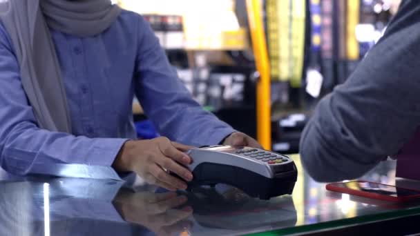 一名上流社会的亚洲穆斯林男子用手机 聪明的家伙在销售终端支付产品的费用 用Nfc识别码支付验证和认证费用 — 图库视频影像