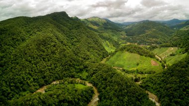 Doi Phuka Dağı 'ndaki yağmur mevsiminde yemyeşil yağmur bulutu içindeki bir köyün havadan görünüşü kuzey Tayland' daki ulusal parkı kaplamıştır.