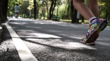 Sporcu parkta koştuktan sonra yürüyor. 