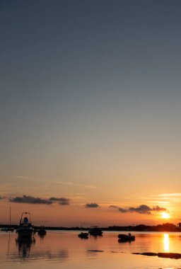 Deniz 'de Günbatımı, kısada botlar, düşey fotograf