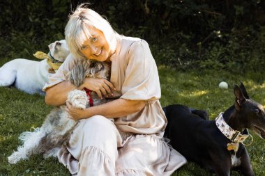 Evcil hayvanlarının keyfini çıkaran bir kadın, mutlu bir şekilde eğleniyor.