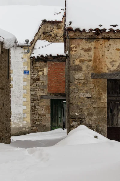 Eski evlerin karla kaplı olduğu bir köy manzarası, dikey fotoğraf.