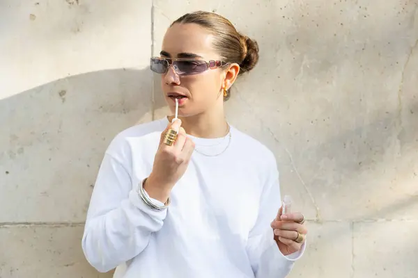 Eine Trendige Frau Weißen Sweatshirt Trägt Lipgloss Auf Während Sie — Stockfoto