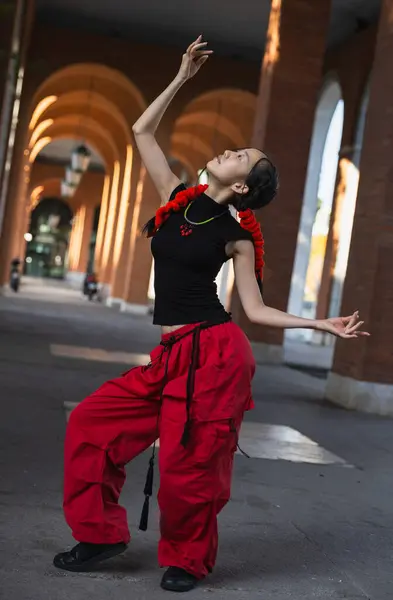 一个穿着红裤的都市女舞蹈家通过她那镇定流畅的动作抓住了东方舞的本质 — 图库照片