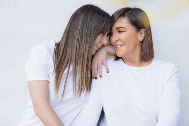 Sevecen bakışlar ve gülümsemelerle şefkatli bir anı paylaşan bir anne ve kızın yürek ısıtan yakın çekimi..