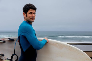 Sörfçü sörf tahtasıyla denize bakıyor..