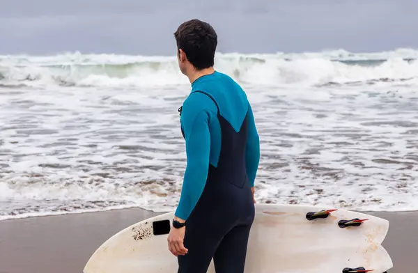 一个冲浪者带着冲浪板 凝视着海浪 准备下水的后视镜 — 图库照片