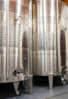 Shiny stainless steel tanks used for wine fermentation and aging, showcasing modern winemaking technology. clipart