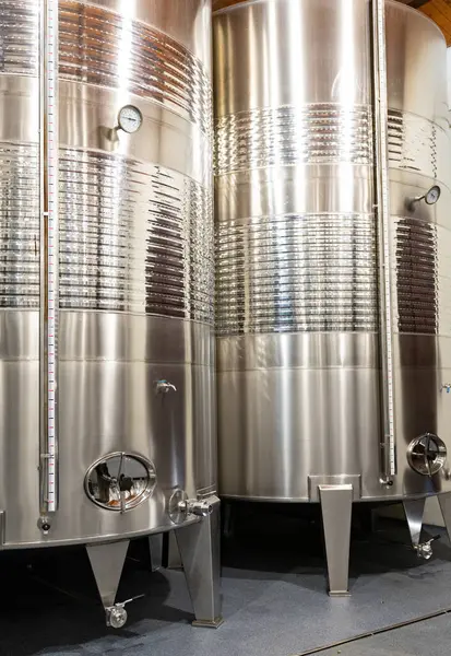 Shiny stainless steel tanks used for wine fermentation and aging, showcasing modern winemaking technology.