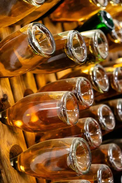 Ciepły Blask Musujących Butelek Wina Ustawionych Drewnianych Regałach Czekających Odpowiedni — Zdjęcie stockowe