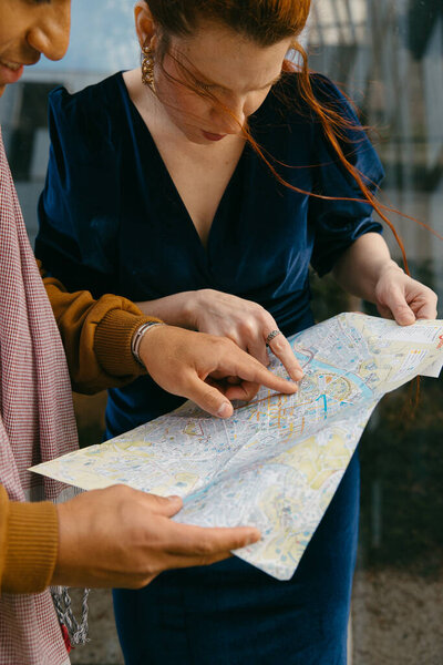 Close-up of a couple of friends consulting the map for locations.