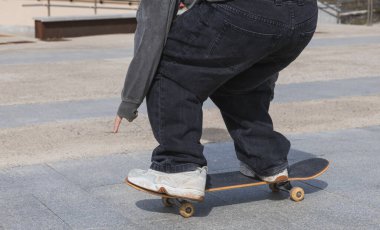 Kaykaycının ayak hareketlerini gösteren detaylı bir yakın çekim kaykay için gerekli stil ve tekniği gözler önüne seriyor..