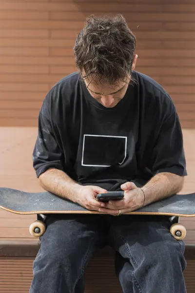 Skatista Faz Uma Pausa Para Verificar Seu Smartphone Sentado Seu — Fotografia de Stock