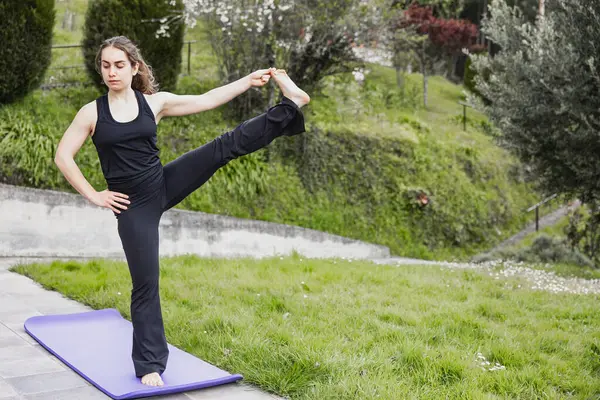 Woman Maintains Challenging Yoga Leg Stretch Pose Mat Serene Outdoor — Stock Photo, Image