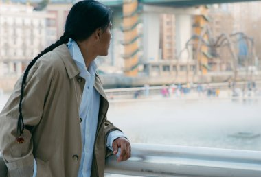 Karakteristik örgüsü olan Ekvadorlu bir adamın kenar manzarası, ünlü bir kent simgesinin keyfini çıkarıyor..