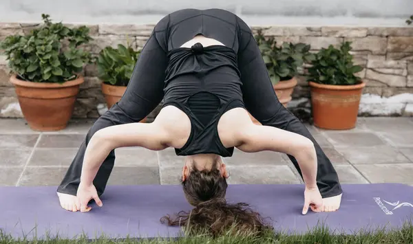 Una Mujer Realiza Una Pose Yoga Una Esterilla Entorno Jardín Fotos de stock libres de derechos