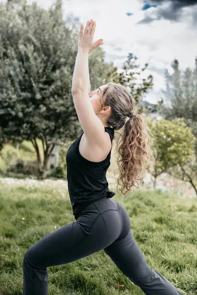 Una Mujer Enfocada Involucra Una Pose Alta Yoga Parque Soleado Imágenes de stock libres de derechos