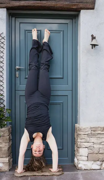 Siyah Kıyafetli Yetenekli Bir Kadın Mavi Bir Kapının Yanında Yoga Stok Resim