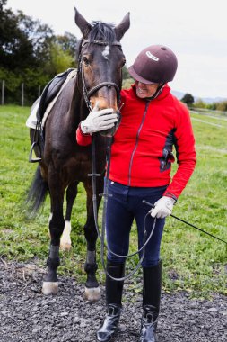 Kıdemli adam gülümseyerek atını okşuyor, boş zamanlarında refakatinin ve huzurlu kırsalın tadını çıkarıyor..