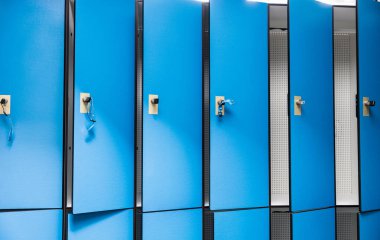 Kapalı havuz soyunma odasında açık kapıları olan mavi dolaplar. Yüzücülerin eşyaları için depo alanı sağlıyorlar..