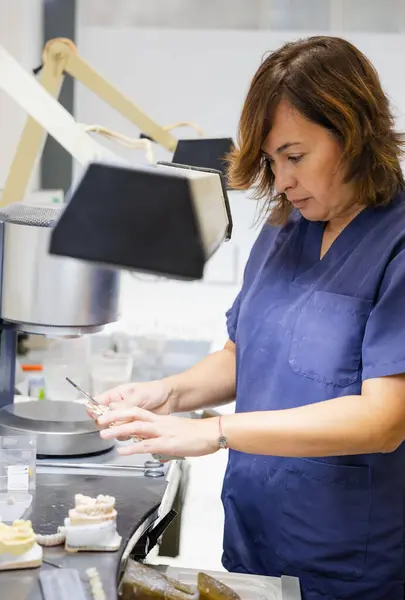 Profesyonel bir laboratuvar ortamında dişçi protezi yapan kadın..