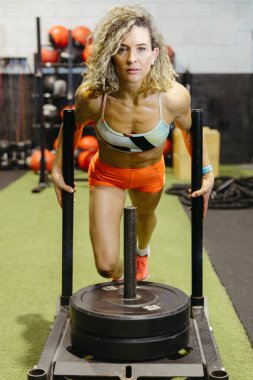 Spor salonunda kızaklı, formda bir kadın eğitimi.