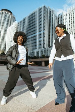 İki siyah arkadaş modern bir şehirde dans ediyor ve arkadaşlıklarının tadını çıkarıyorlar.