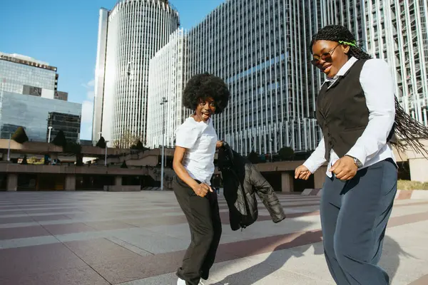 İki siyah arkadaş şehirde neşeyle dans ediyor ve hayatın tadını çıkarıyorlar.