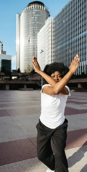 Modern bir şehirde enerji ve stille dans eden siyahi kadın.