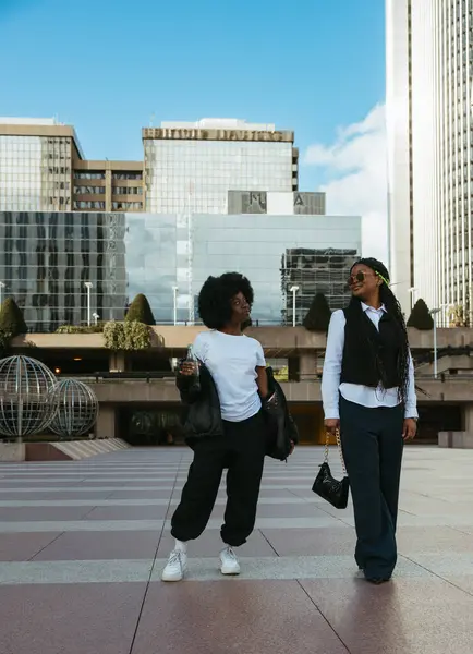 Şehir ticaret bölgesinde dans eden iki genç kadın.