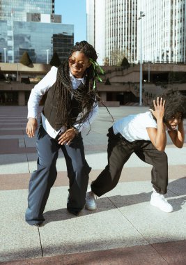 Şehir meydanında dans eden iki genç siyahi kadın
