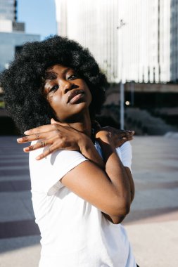 Kendine güveni olan Afro kadın kameraya anlamlı bir pozla bakıyor.