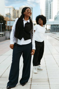 Afro arkadaşlar dışarıda dans ettikten sonra gülümsüyor ve dinleniyorlar.