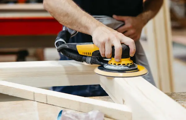 Profesyonel bir atölyede zımpara makinesiyle ahşabı zımparalıyorum.