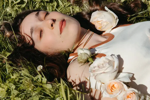 Bahçede doğal güllerin arasında dinlenen rahat kadın portresi.