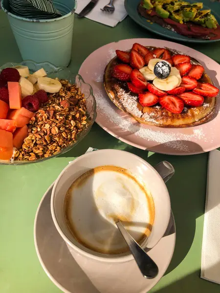 Yoğurt, granola, krep ve terasta kahve ile sağlıklı bir kahvaltı.